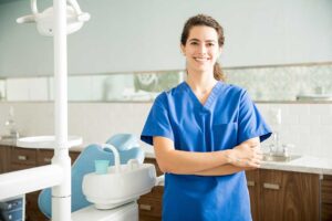 Person gently curving dental floss around a tooth at the gumline in a bright bathroom.